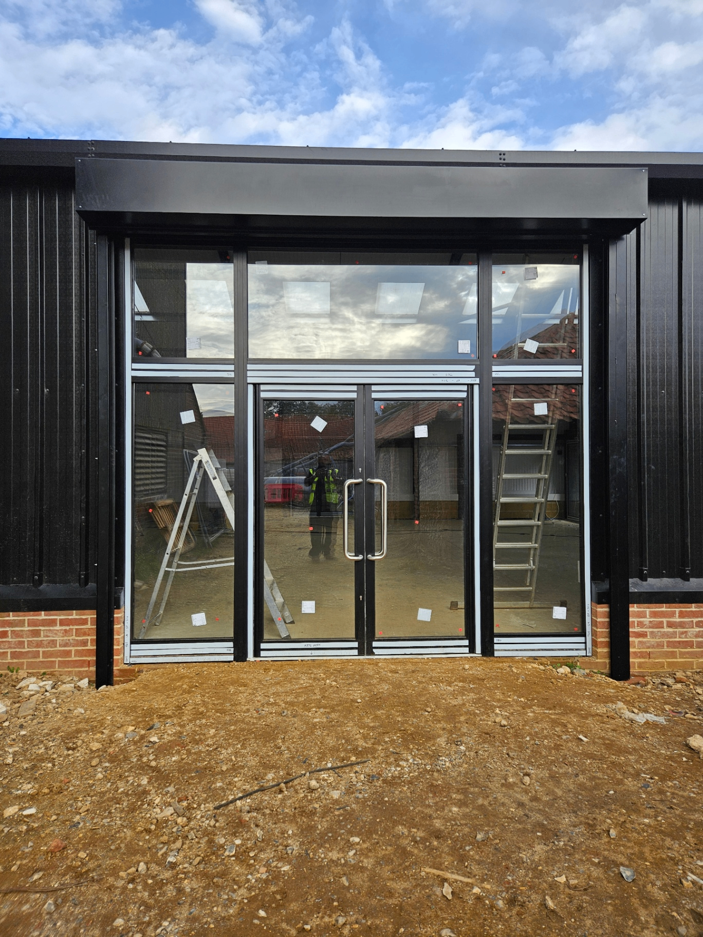 Black aluminium shopfront with double doors on a newbuild commercial unit – Prestige Aluminium Systems