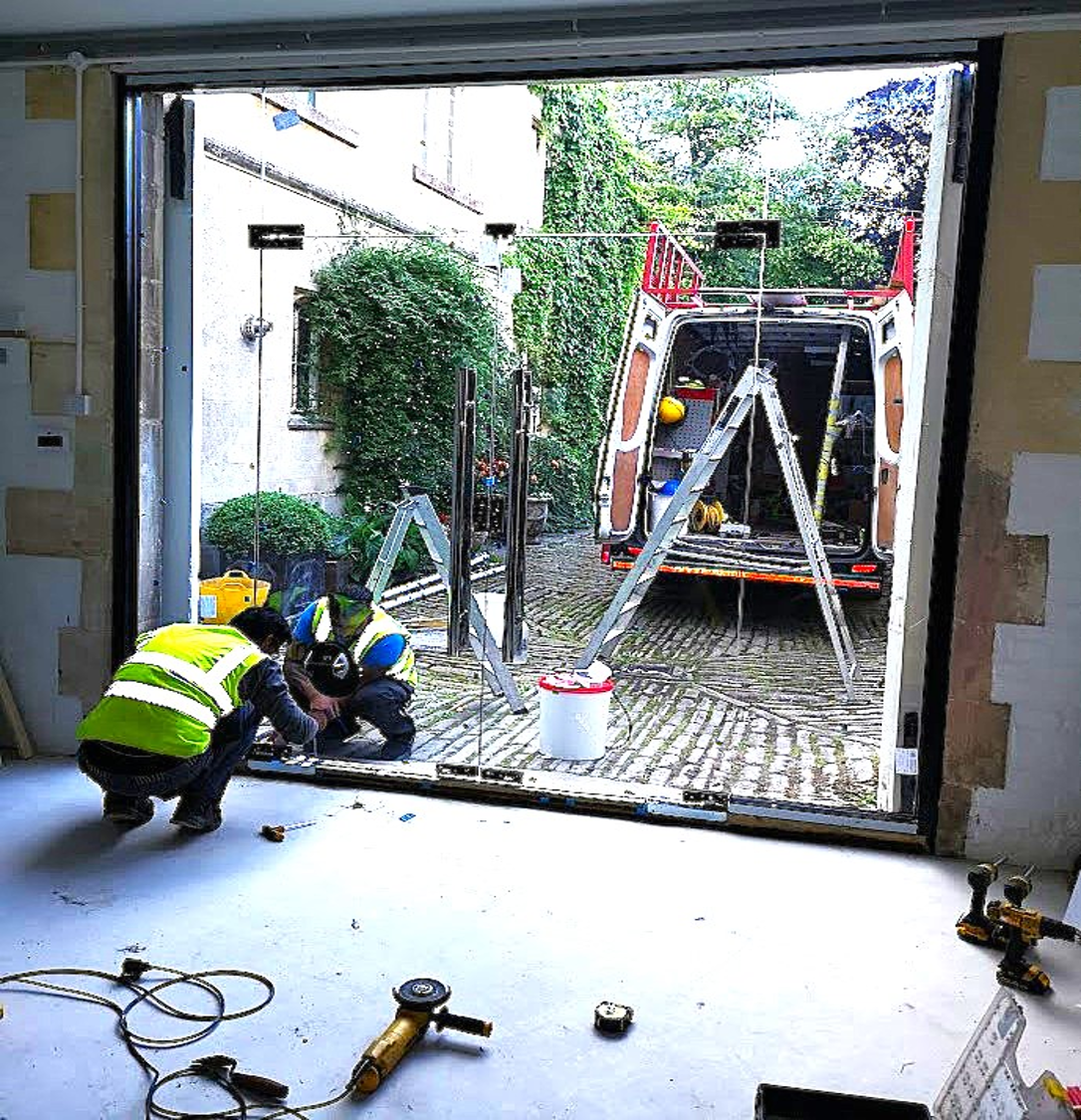 Installers fitting a bespoke timber shopfront on a commercial unit – Prestige Aluminium Systems